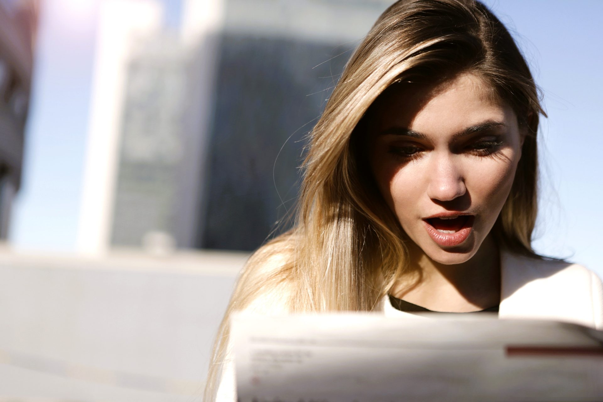 Une femme lit un livre d'un air choqué.