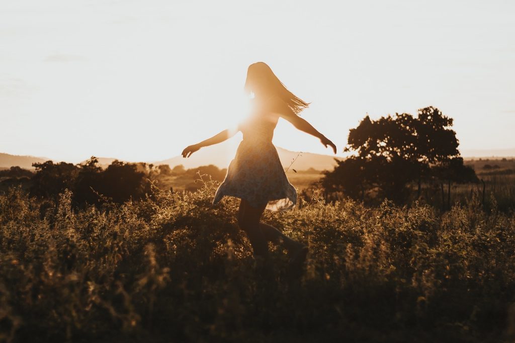 Une femme danse sous le soleil.