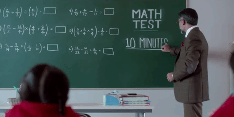 Un professeur écrit un test de maths sur le tableau.