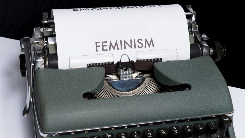 Machine à écrire avec le mot féminisme en anglais écrit sur un papier.