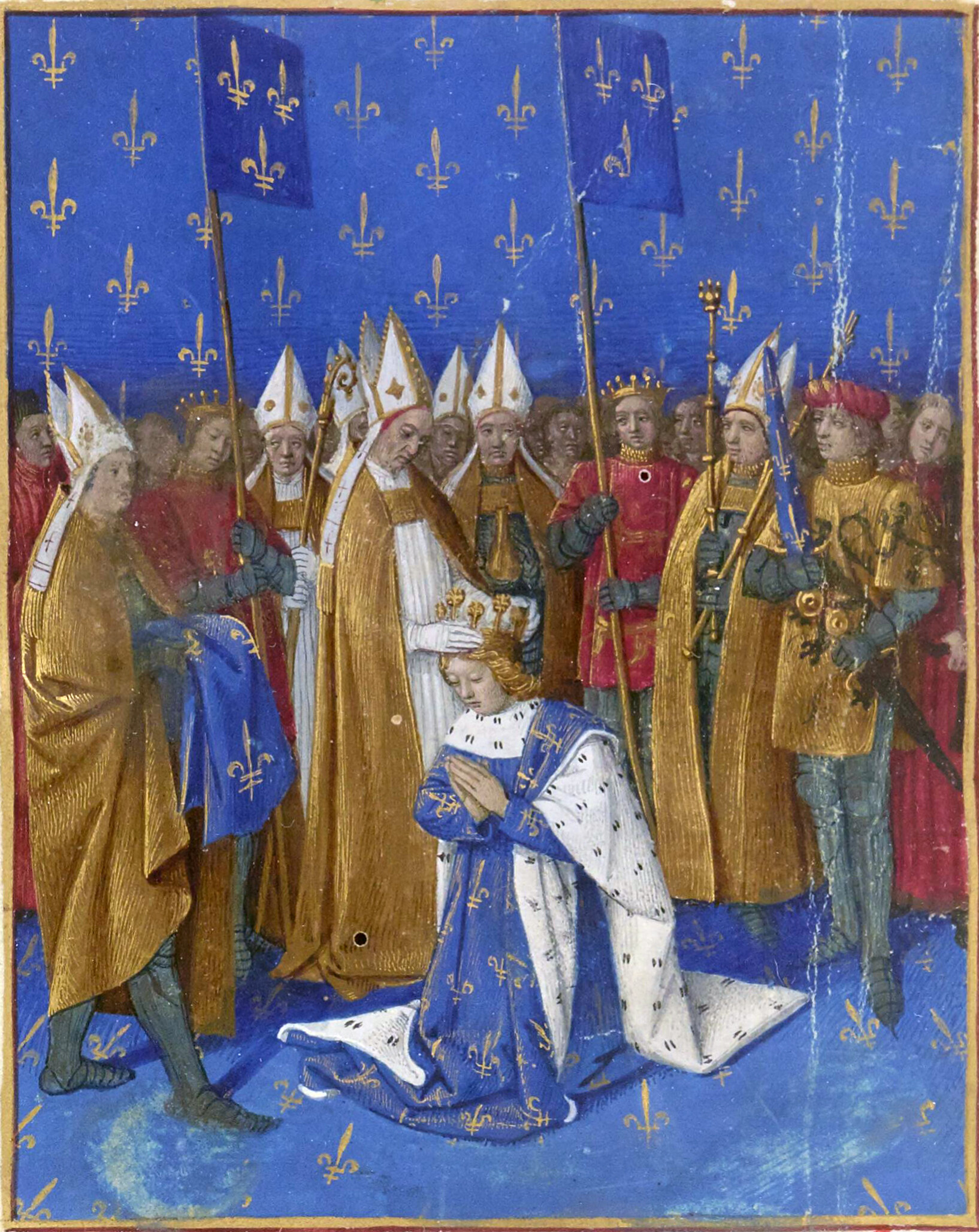 Cette image représente une scène de couronnement, probablement celle de Charles VI de France, dans un manuscrit enluminé. Le jeune roi est représenté agenouillé, vêtu d'un manteau orné de fleurs de lys, un symbole de la royauté française. Un prélat, probablement l'archevêque, lui impose la couronne, un moment solennel du rituel de couronnement. Autour du roi, plusieurs personnages sont présents, dont des clercs en habits liturgiques et des chevaliers en armure, également portant des bannières bleu royal décorées de fleurs de lys. Le fond est d'un bleu intense, orné de motifs de fleurs de lys, ajoutant une dimension décorative à cette scène officielle.