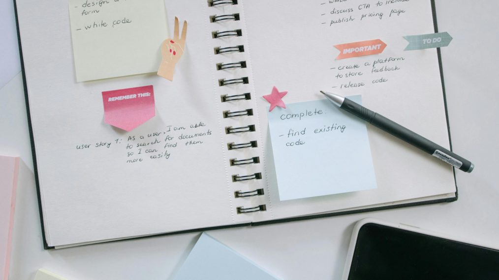 Image d'un cahier avec des crayons et des post-it.