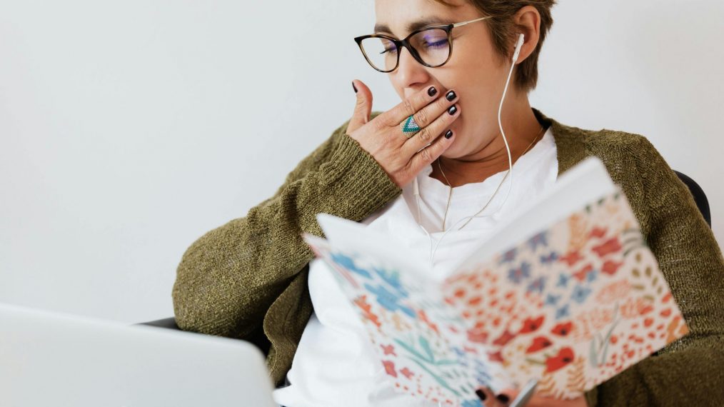 Une femme bâille et elle est en train de travailler.