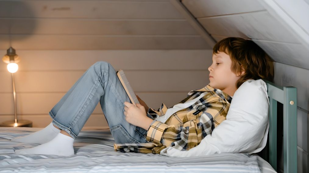 Un enfant lit un livre.