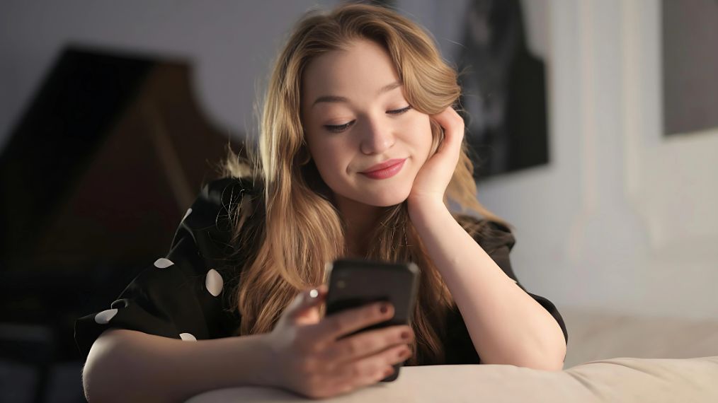 Une jeune fille avec son téléphone à la main.
