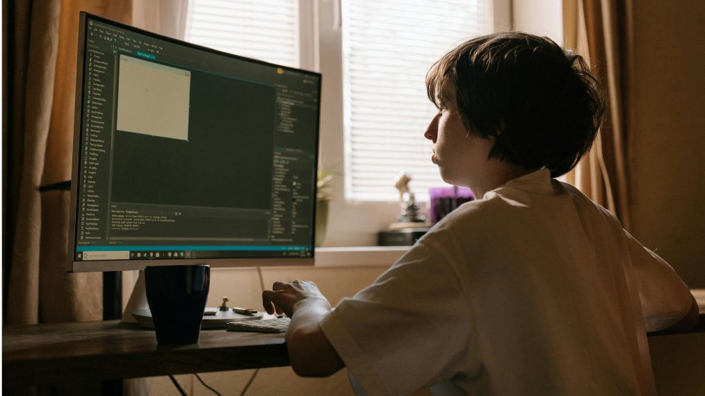 Un jeune travaille sur un ordinateur.