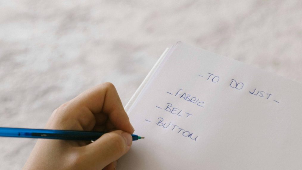 Image d'une personne qui écrit sur une feuille.