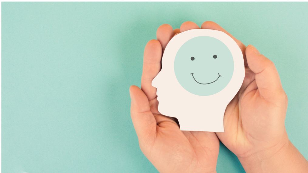 mains tenant un dessin d'une tête et d'un sourire